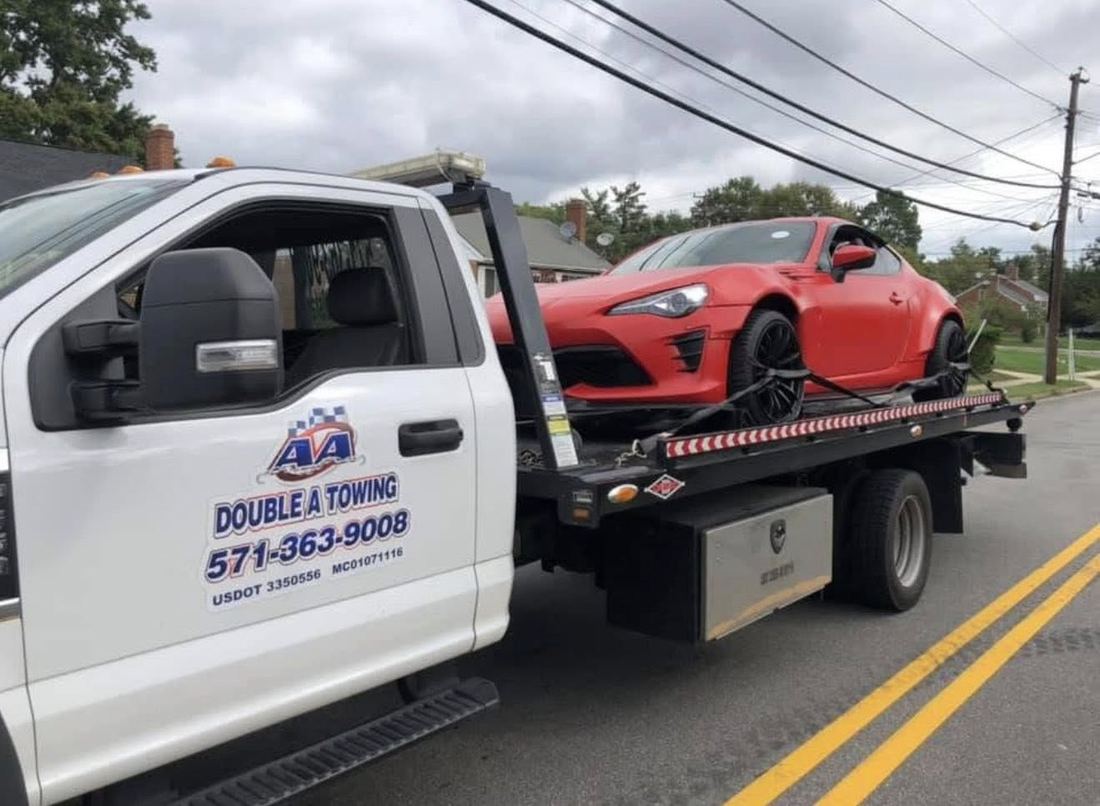 Red sports car secured on a Double A Towing flatbed