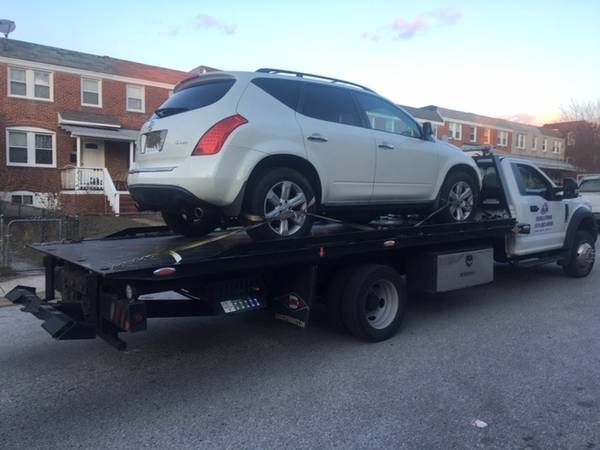 White SUV loaded on a Double A Towing flatbed